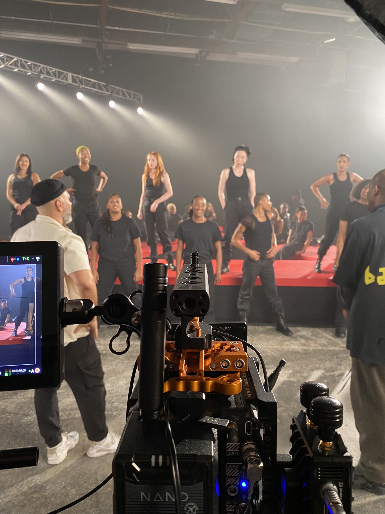 dancers lined up on runway with camera rig